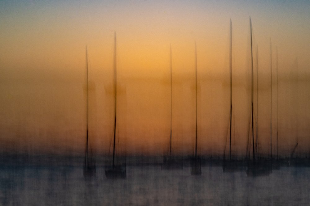 Veleiros ao pôr-do-sol desfocados de Franco Tessarolo