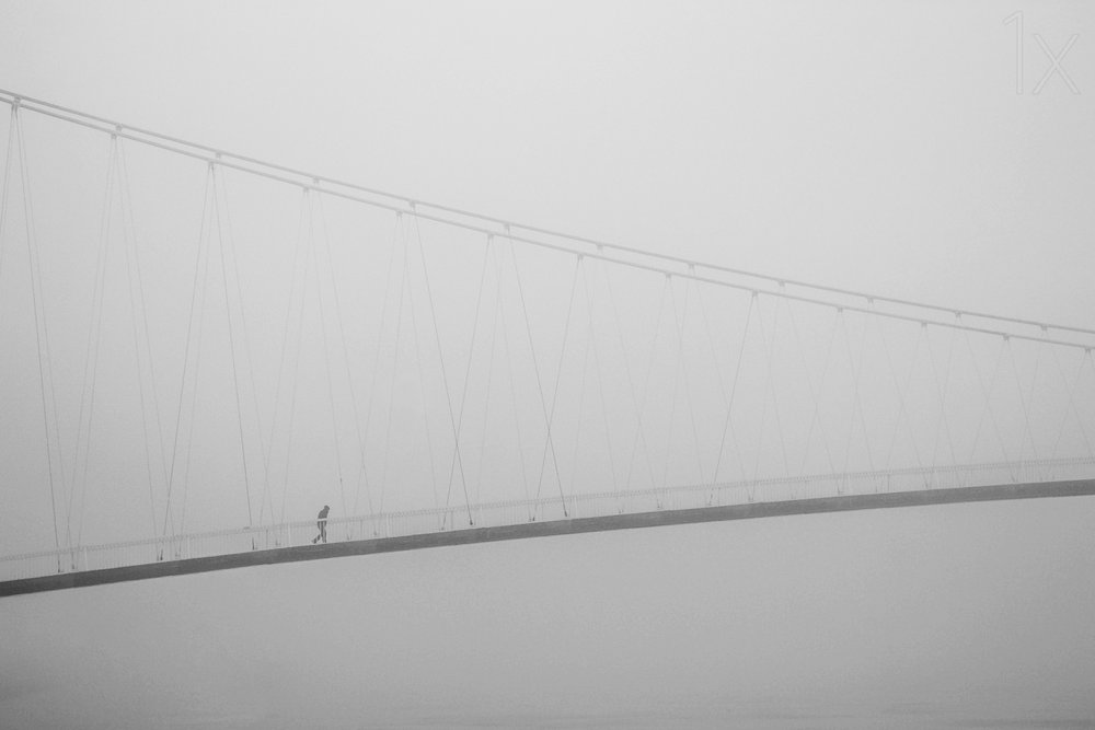 Passeio solitário numa ponte enevoada de Krunoslav Nevistic
