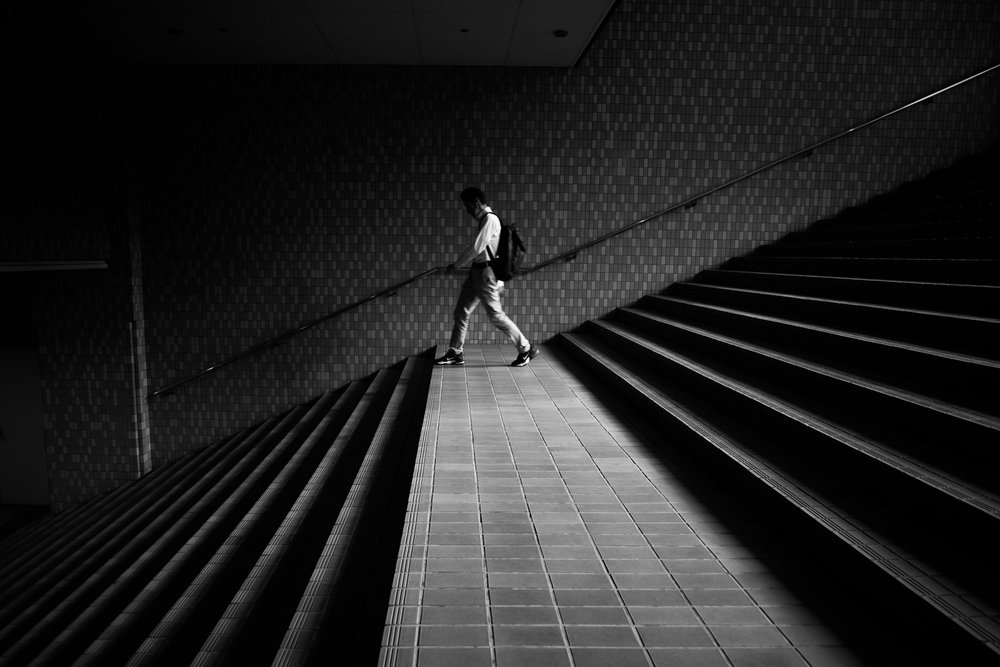 Homem numa escadaria geométrica de Satoshi Hata