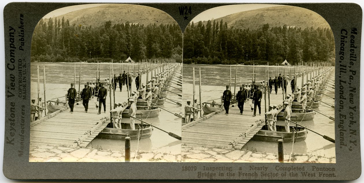 Horizontal, stereocard do sepia que mostra os oficiais uniformizados que cruzam uma ponte de pontão com os homens que estão nos pontões em ambos os lados da ponte. Número do estereógrafo Keystone 18079 de Keystone View Company