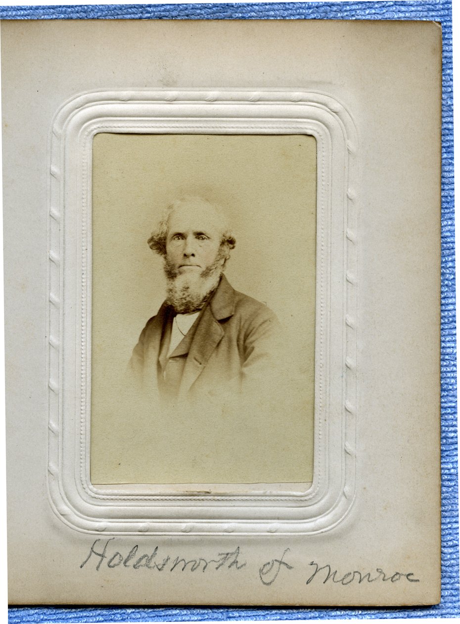Busto retrato de um homem de barba com cabelo encaracolado, vestindo um terno e virou-se ligeiramente para a esquerda. de Outley