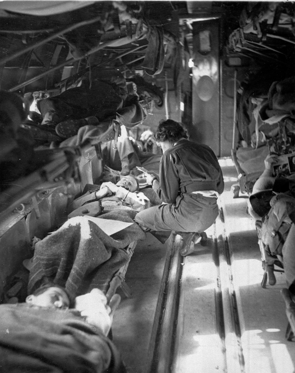 Miss Mary Smith, da Carolina do Sul, tratando pacientes durante o vôo para o norte da África, c.1943-45, de uma coleção de 650 fotografias compiladas pela Commando Association de American Photographer