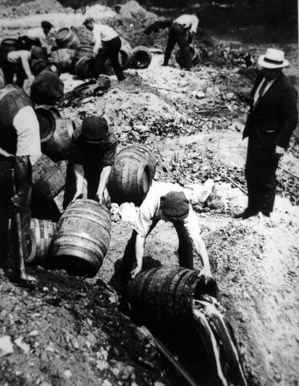 Um agente federal americano supervisiona a destruição dos barris de cerveja durante a era da proibição americana (1920-33) (foto a p/b) de American Photographer