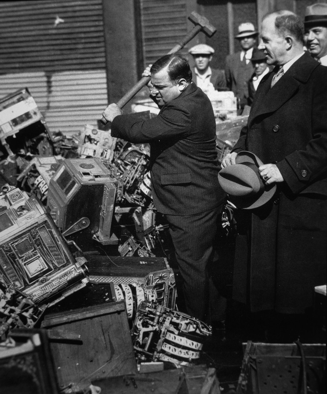 Fiorello La Guardia (1882-1947) esmagando slot machines confiscadas de American Photographer