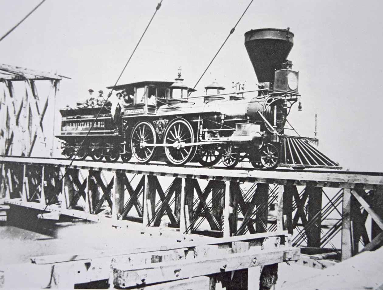 Locomotiva das Ferrovias Militares dos EUA (Exército da União) atravessando a ponte de cavalete sobre o rio Potomac (foto a p/b) de American Photographer