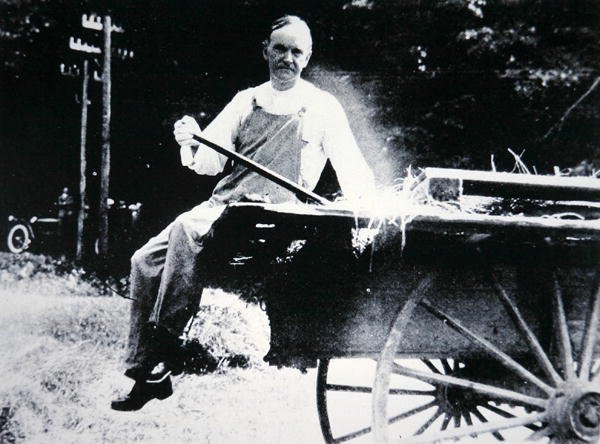 Presidente Calvin Coolidge (1873-1933) posando como fazendeiro durante umas férias em Vermont (foto a p/b) de American Photographer