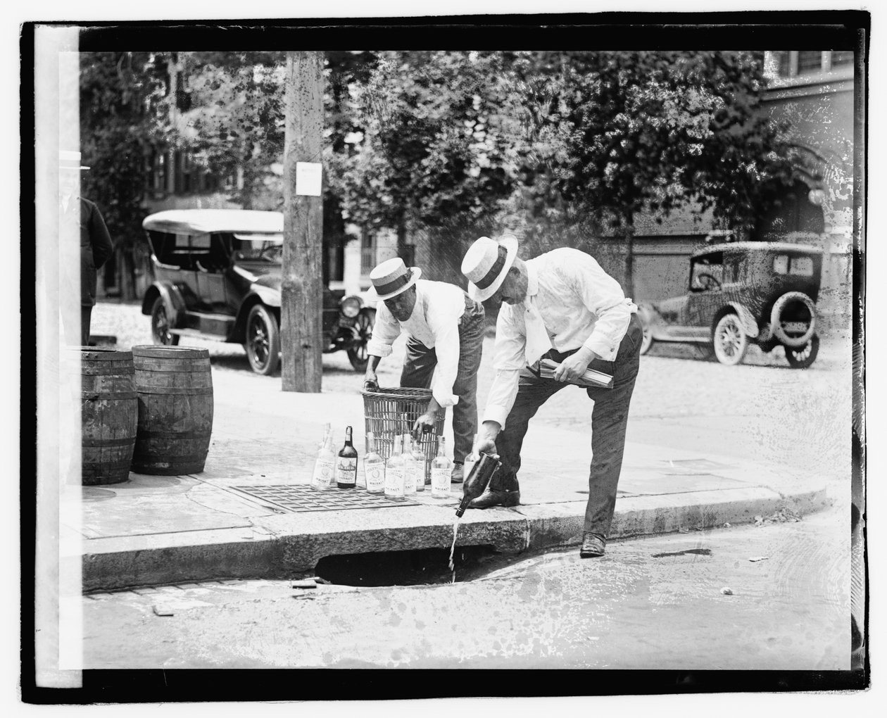 Dois homens despejando bebida no bueiro, 8 de julho de 1921 (foto em branco) de American Photographer