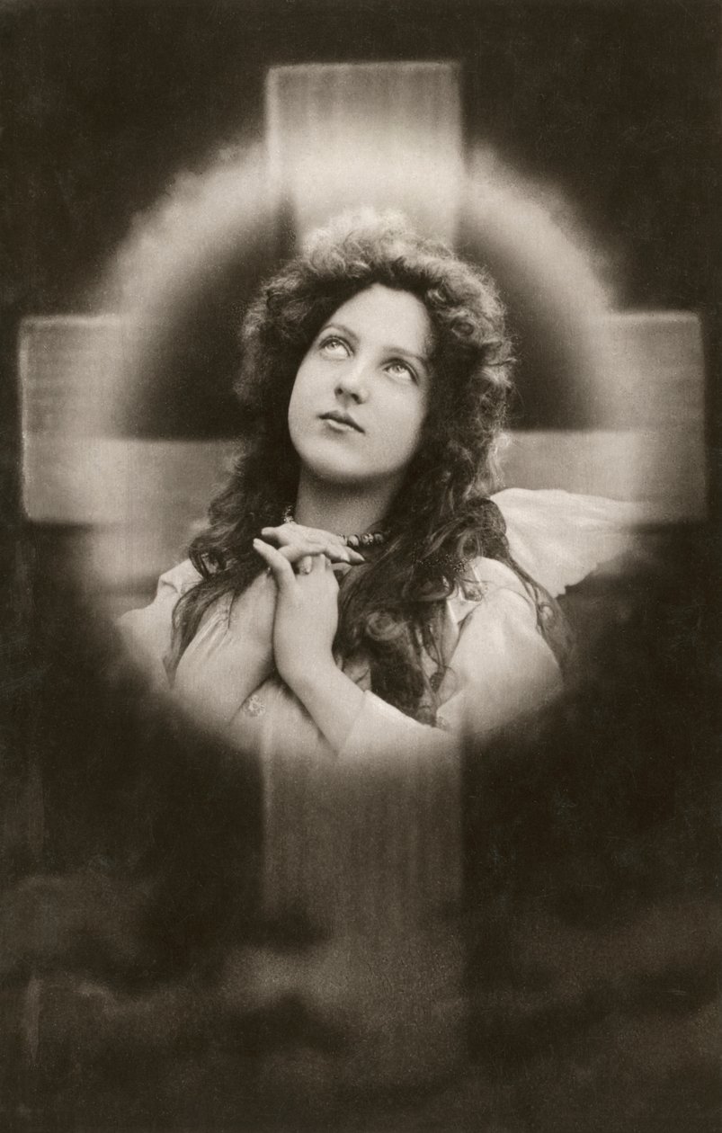 Mulher devota a rezar diante de uma cruz de American School