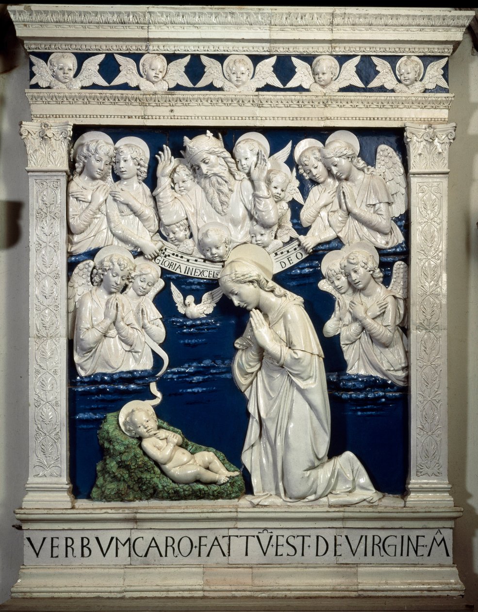O Nativite. Representação da Santíssima Trindade com Deus, Jesus Cristo e a pomba do Espírito Santo. Cerâmica em alto relevo por Andrea della Robbia de Andrea Della Robbia