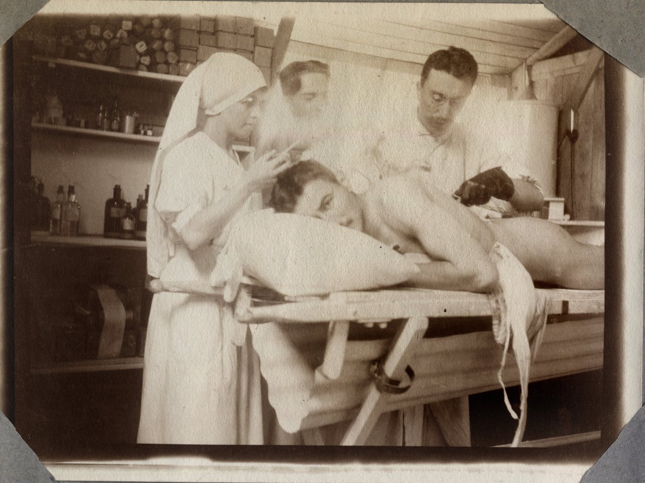 Primeira Guerra Mundial 1914-1918: médicos e enfermeiros tratando de feridas de um soldado no camarim, acampamento de Couville no Canal da Mancha, Baixa Normandia, França. Fotografia anônima de julho de 1917. Coleção particular, Stella. de Anonymous Anonymous