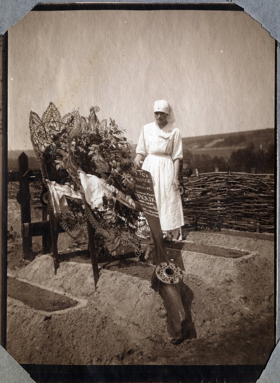 Primeira Guerra Mundial 1914-1918: enfermeira (Therese Pavillou?) numa blusa sobre o túmulo do sargento piloto francês Roux, morto aos 21 anos de idade, em Couville, Manche, Basse-Normandie (Baixa Normandia), França. Fotografia anónima de Julho de 1917. Co de Anonymous Anonymous