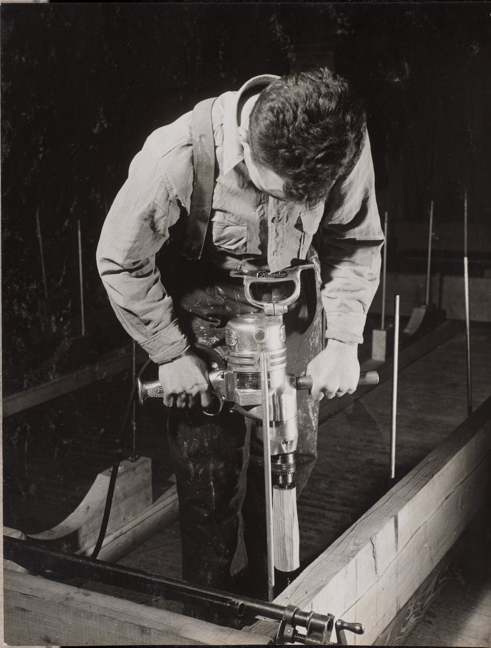 [Um homem utiliza uma máquina manual para trabalhar com um pedaço de madeira]. de Arnold Eagle