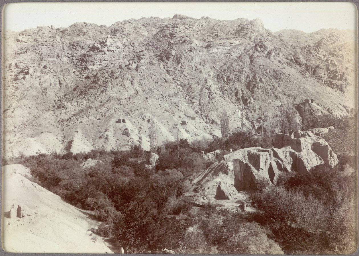 Cume com santuários budistas arruinados no pomar de Wang em Ara-tam, Hami, China de Aurel Stein