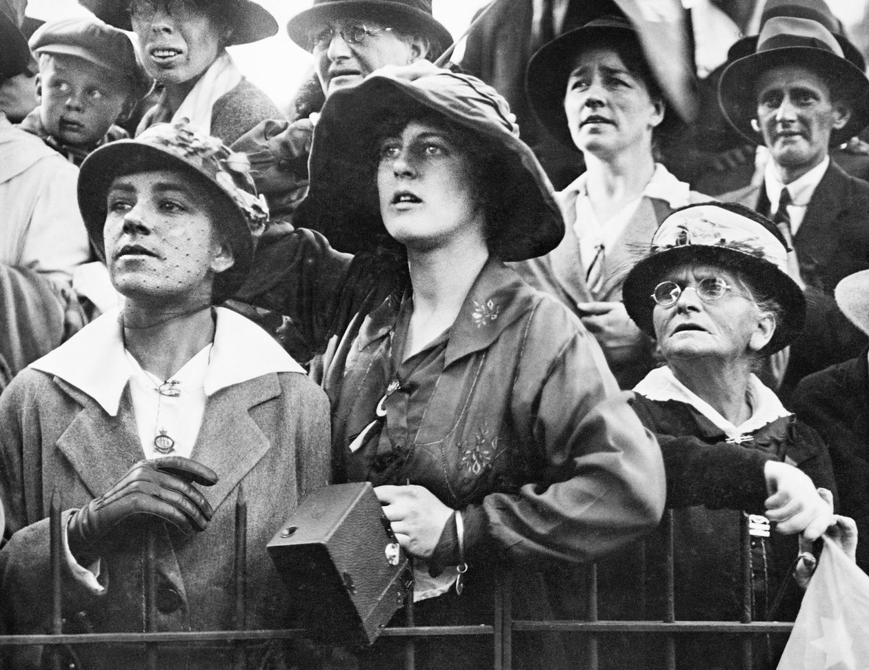 Um grupo de mulheres na multidão estuda expressões no Anzac Buffet em Hyde Park, onde as relações esperavam para receber os entes queridos, incluindo alguns feridos, enquanto os carros (não vistos) desenhavam de Australian Photographer