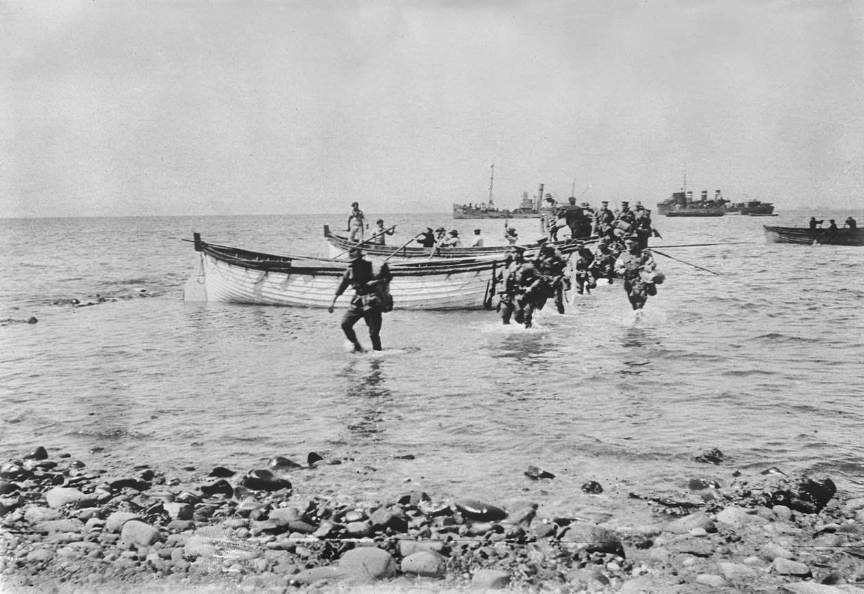 Soldados australianos atravessando a água ao desembarcarem em Anzac Cove, Gallipoli, em 25 de abril de 1915, após serem transportados em barcos de desembarque de navios maiores ao fundo, em 25 de abril de 1915 ( de Australian Photographer