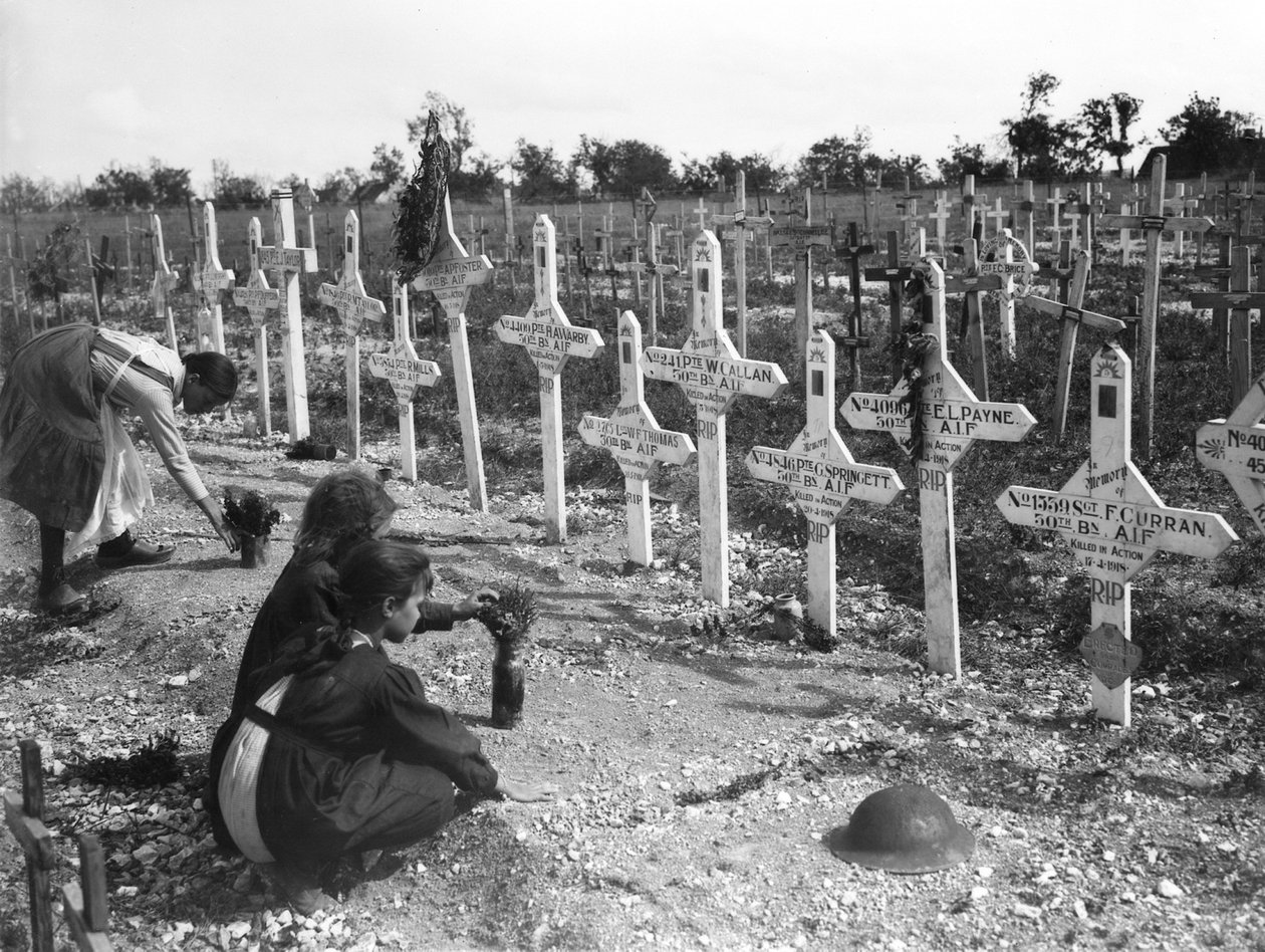 Crianças francesas cuidando de sepulturas em Adelaide Cemetery de australianos mortos em batalha no front ocidental, Villers-Bretonneux, França 26 de agosto de 1919 de Australian Photographer