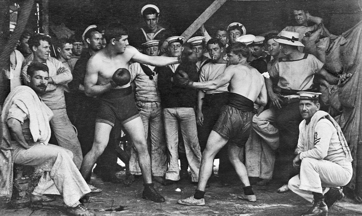 Marinheiros não identificados assistem a uma luta de boxe no meio deles a bordo do HMAS Melbourne, em 1915 de Australian Photographer