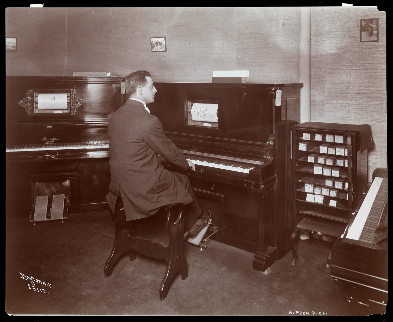 Um homem tocando um piano de jogador em um showroom de piano em Nova York, 1907 (impressão de gelatina de prata) de Byron Company