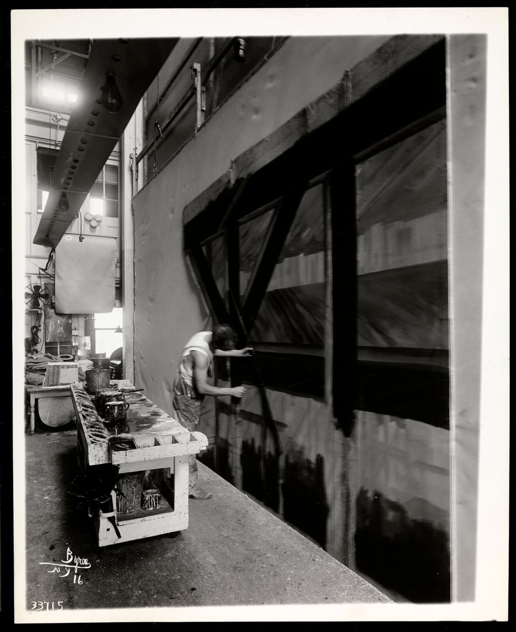 Um artista cênico pintando um apartamento em uma loja de cena, Nova York, 1915-6 (impressão de gelatina de prata) de Byron Company