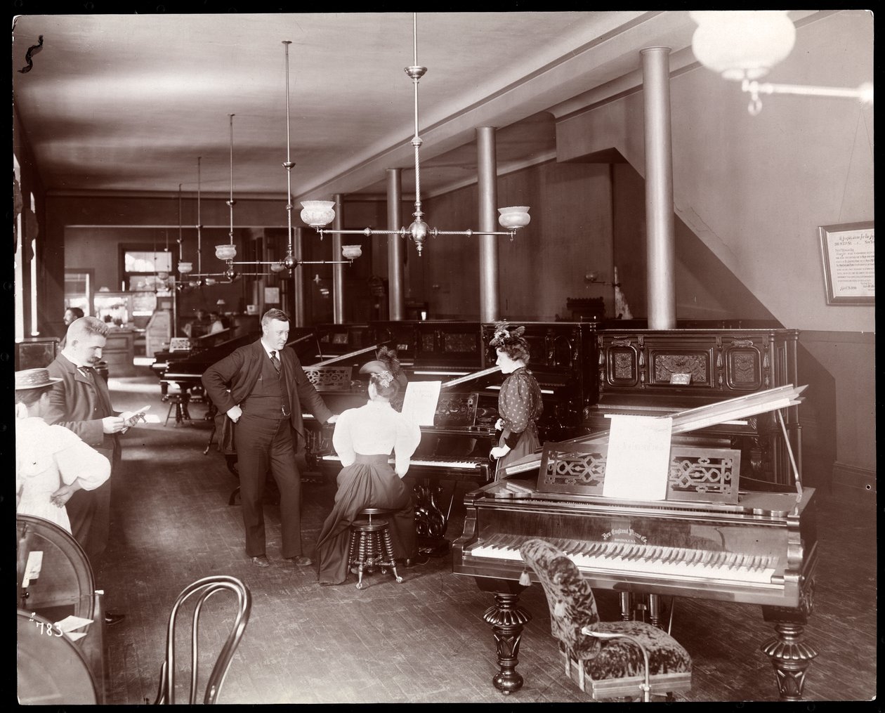 Um showroom da New England Piano Co., 1895 (impressão em gelatina de prata) de Byron Company