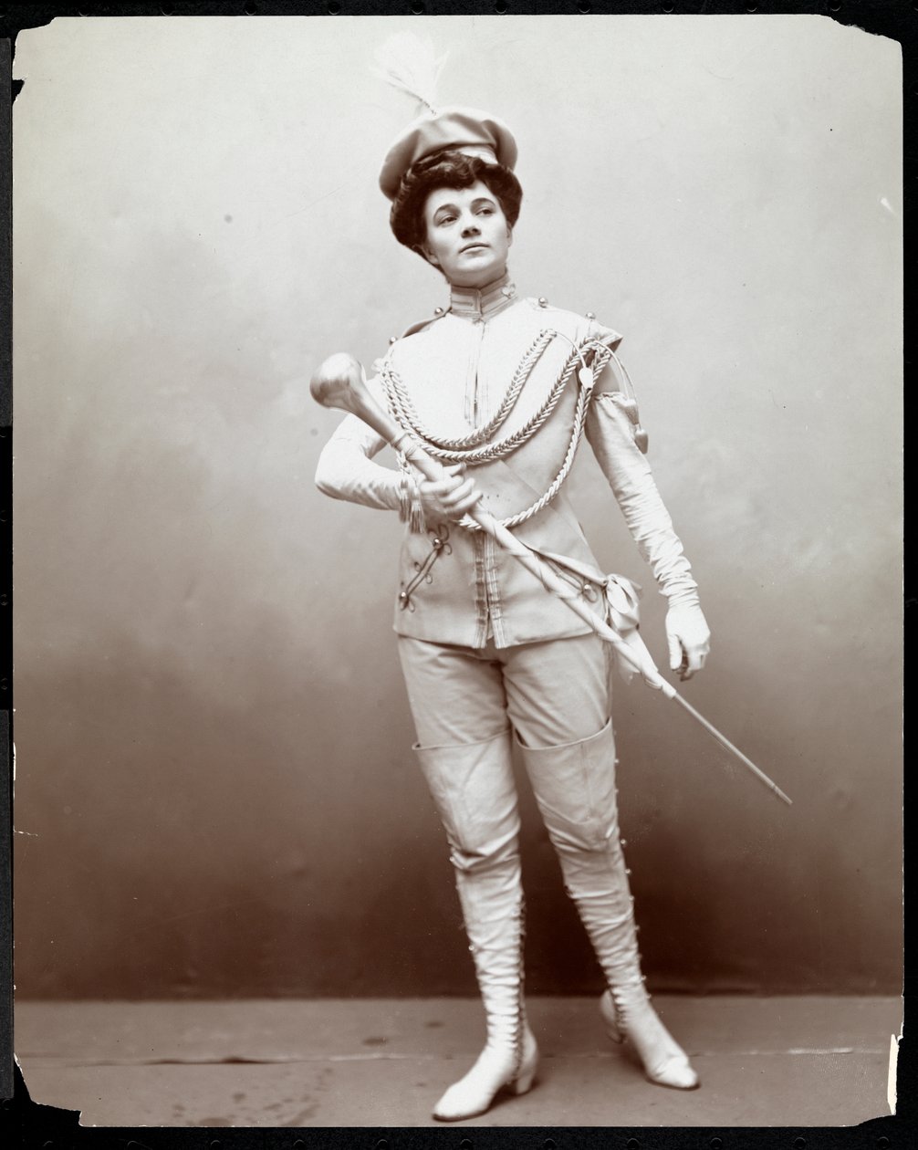 Uma mulher modelando um uniforme de banda, segurando um bastão, c.1898 (impressão de gelatina de prata) de Byron Company