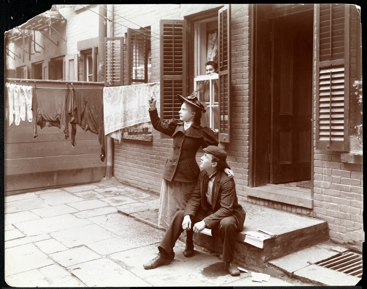 Um jovem e uma mulher posaram em uma porta, Nova York, 1896-98 (impressão de gelatina de prata) de Byron Company