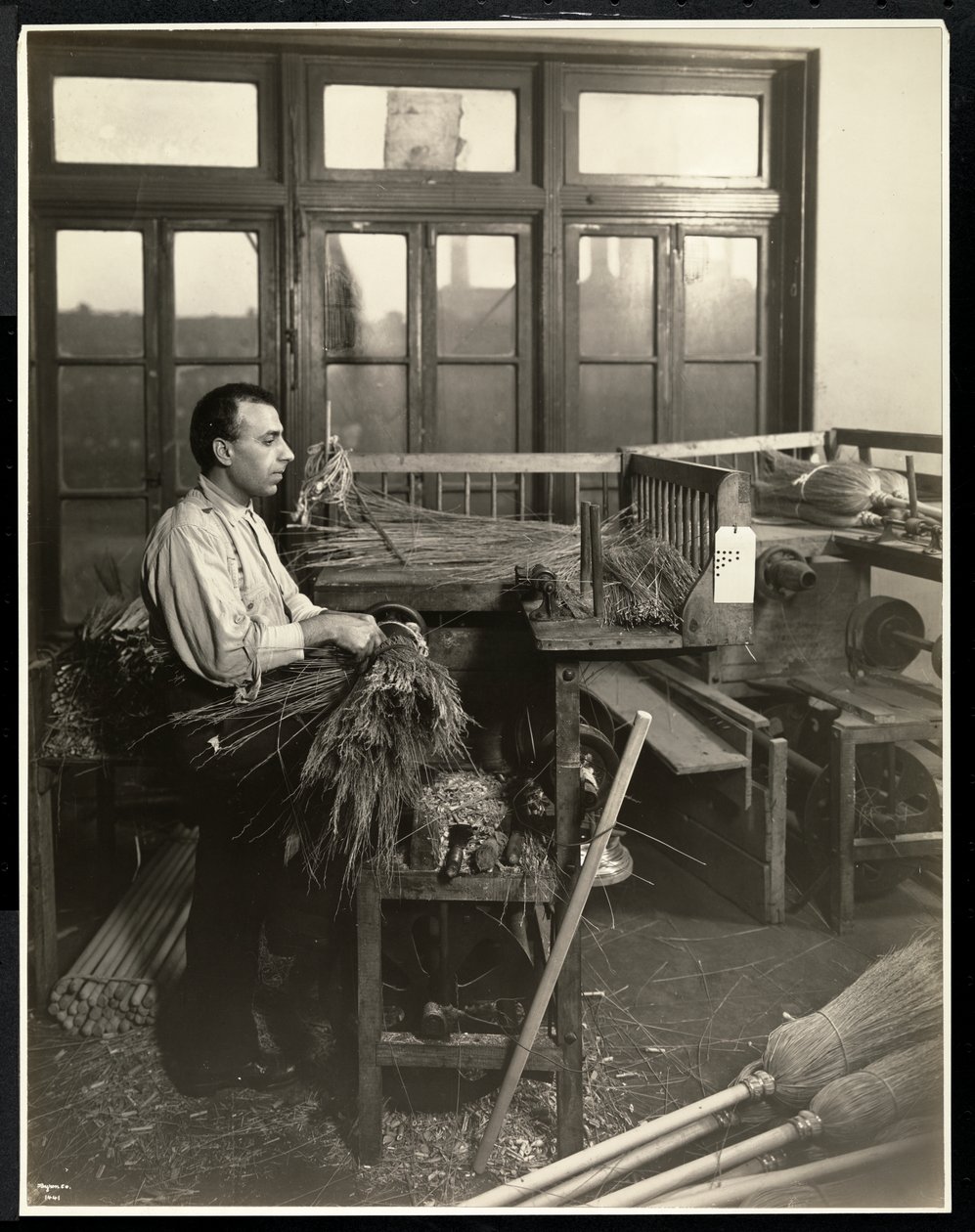 Homem cego que prende palha em cabos de vassoura no Edifício Memorial Bourne, Nova York, 1921 (impressão em gelatina de prata) de Byron Company