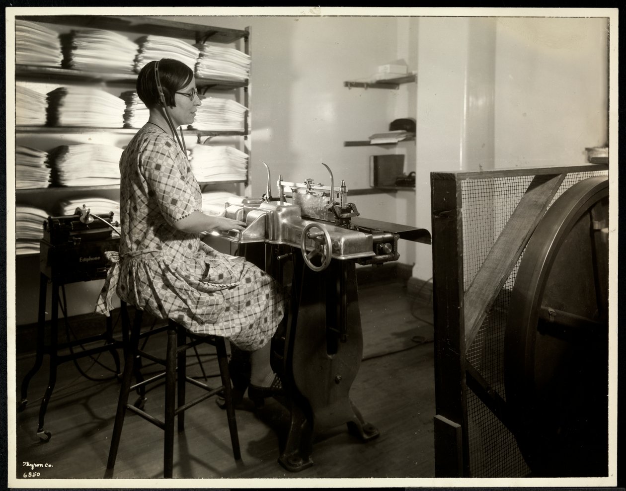 Mulher cega, presumivelmente Charlotte Rohr, trabalhando com uma prensa braille, ditafone e estereótipo, Nova York, 1933 (impressão em gelatina de prata) de Byron Company