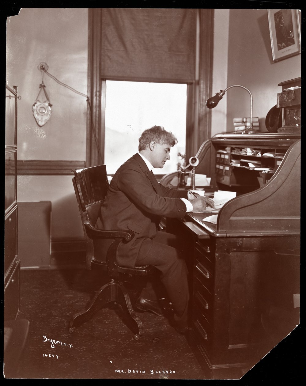 David Belasco escrevendo em uma mesa nos escritórios de seu teatro, 1902 (impressão em gelatina de prata) de Byron Company