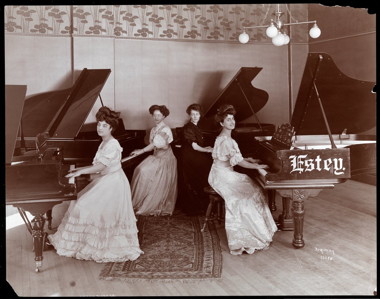 Quatro mulheres sentadas em pianos na Estey Piano Corporation, 1908 (impressão em gelatina de prata) de Byron Company
