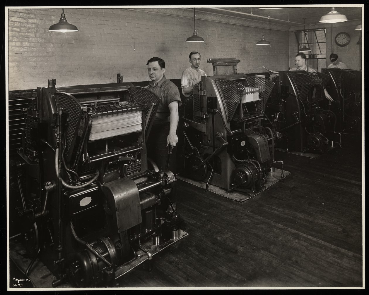 Homens trabalhando impressoras na Unz und Co., 24 Beaver Street, Nova York, 1932 (impressão de gelatina de prata) de Byron Company