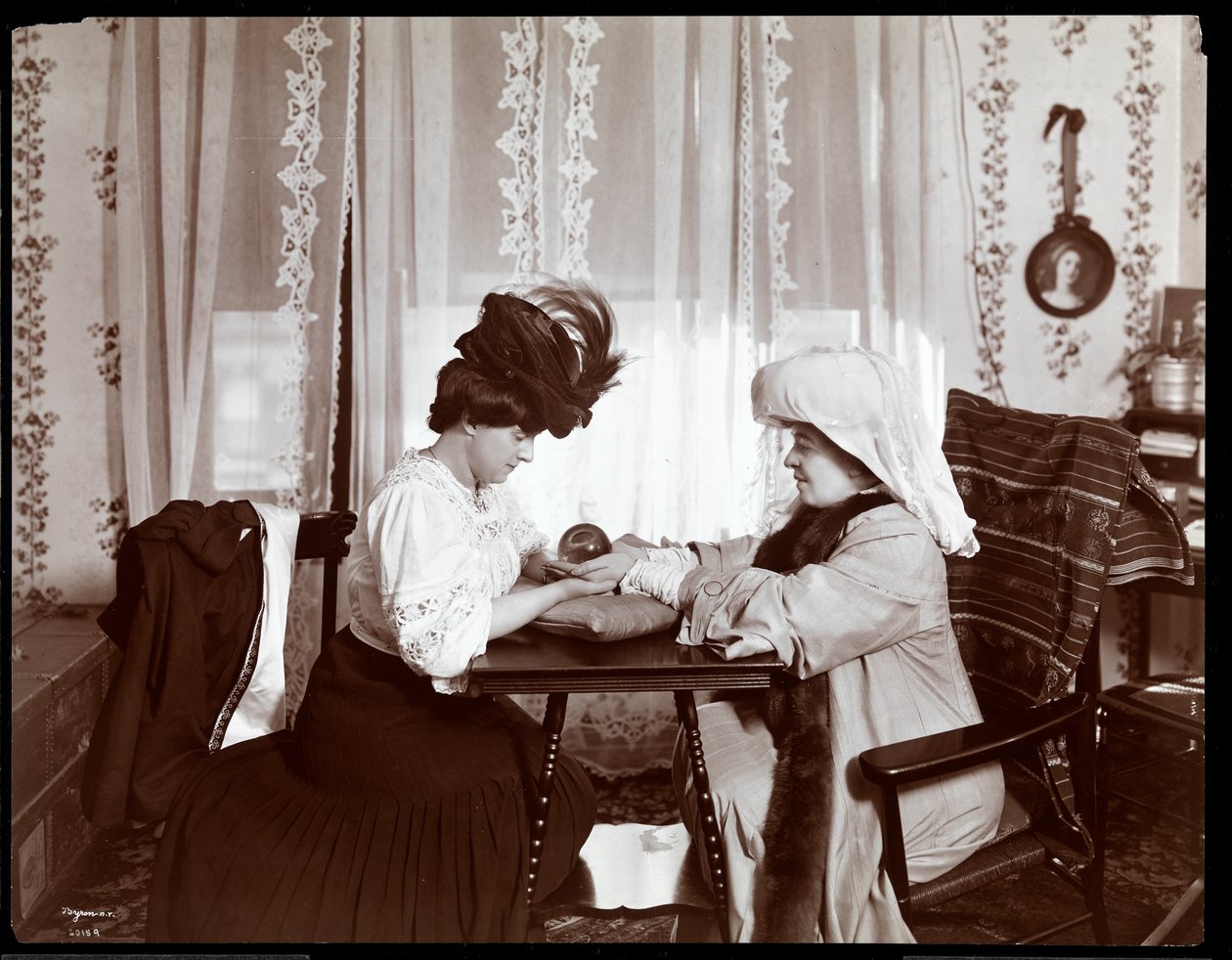 Sra. Leslie Carter sentada com uma mulher lendo uma bola de cristal, 1904 (impressão de gelatina de prata) de Byron Company