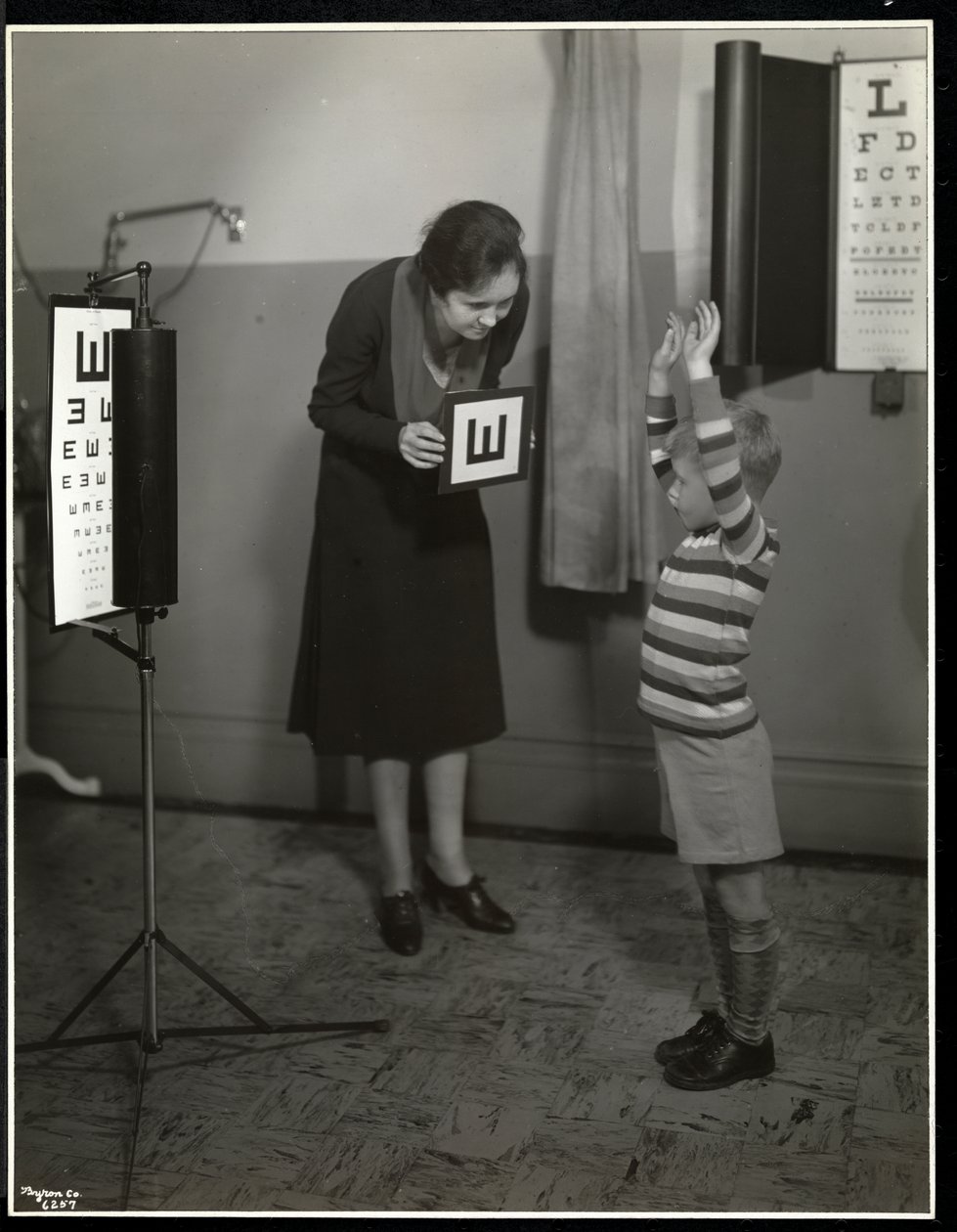 Enfermeira e paciente do sexo masculino com um exame ocular na Associação dos Cegos de Nova York, 111 East 59th Street, Nova York, 1930 (impressão em gelatina de prata) de Byron Company