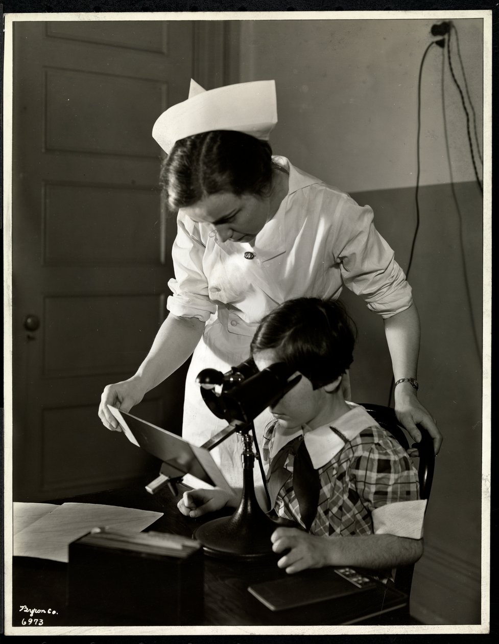 Enfermeira e uma menina com deficiência visual na clínica da Associação para Cegos de Nova York, 114 East 60th Street, Nova York, 1934 (impressão em gelatina de prata) de Byron Company