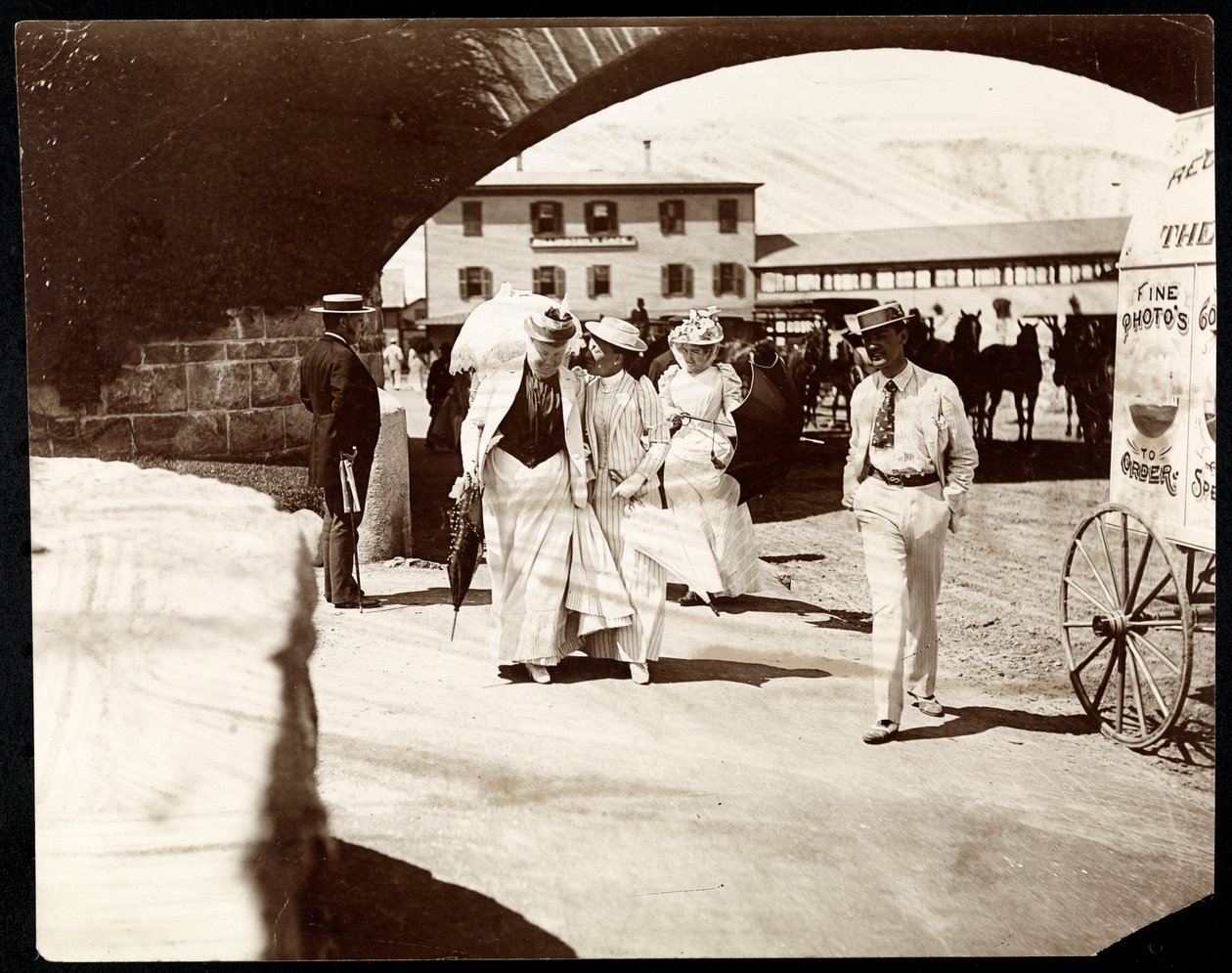 Três mulheres e um homem caminhando no Cais de Narragansett com o carrinho do fotógrafo itinerante, Rhode Island, 1891 (impressão em gelatina de prata) de Byron Company