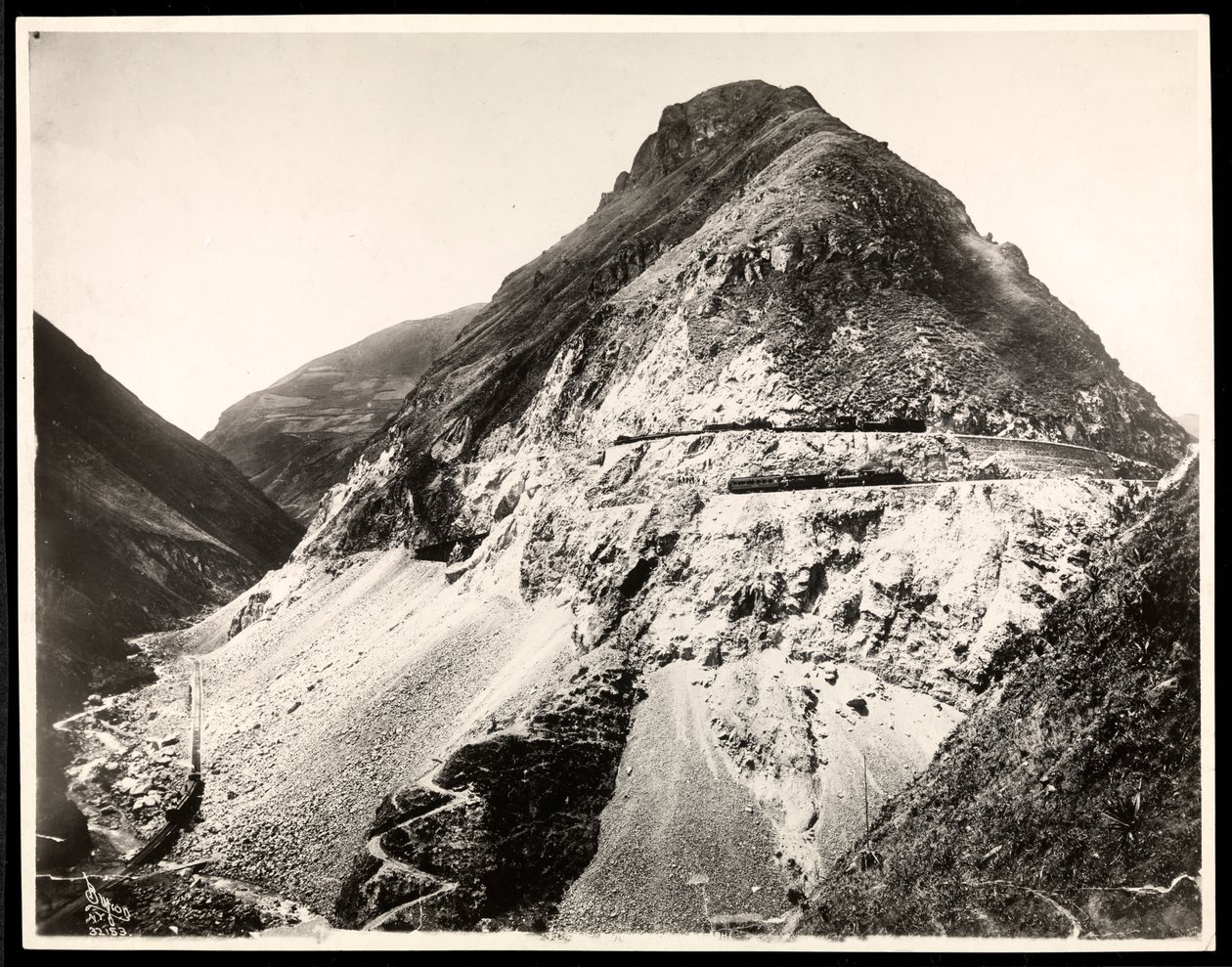 Vista de dois trens ferroviários em trilhas ao longo de uma montanha, presumivelmente sobre ou perto do Canal do Panamá, 1912 ou 1913 (impressão em gelatina de prata) de Byron Company