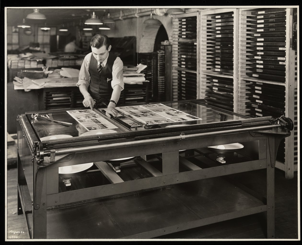 Trabalhando em um layout em uma mesa de luz na Unz und Co., 24 Beaver Street, Nova York, 1932 (impressão de gelatina de prata) de Byron Company