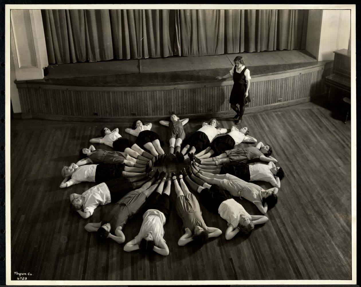 Jovens mulheres cegas, deitado em um padrão de starburst no chão do ginásio da Associação Nova Iorque para os cegos, 111 East 59th Street, Nova York, 1933 (impressão de gelatina de prata) de Byron Company
