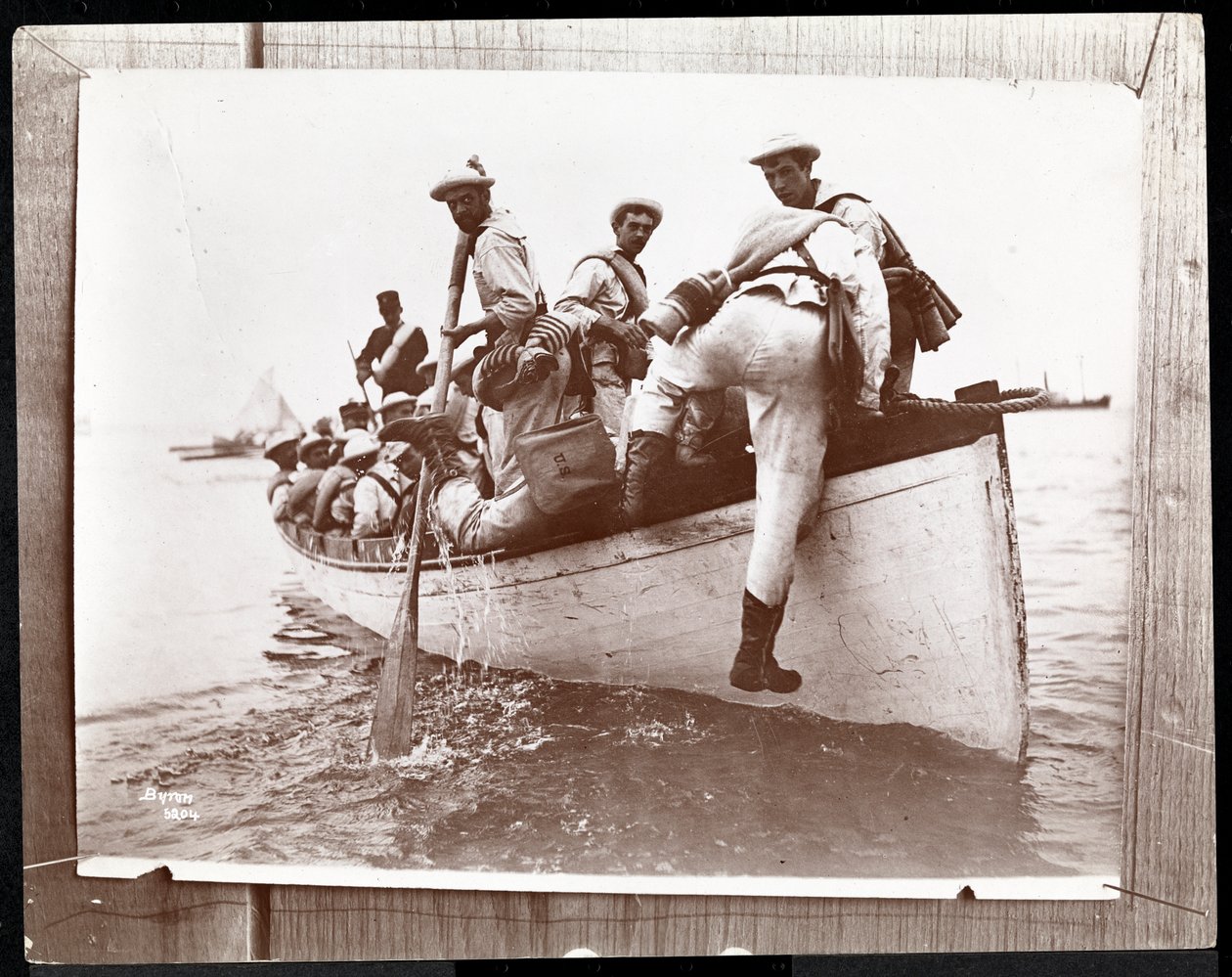 Copyphotograph de uma foto anterior das Reservas Navais na Ilha dos Pescadores, Nova York com um grupo de marinheiros em um barco a remo, 1898 (impressão de gelatina de prata) de Byron Company