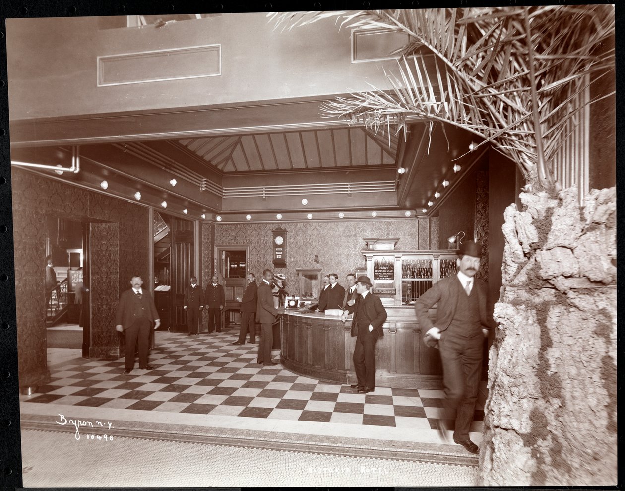O lobby e o balcão de registo no Hotel Victoria, 1900 ou 1901 (impressão em gelatina prateada) de Byron Company