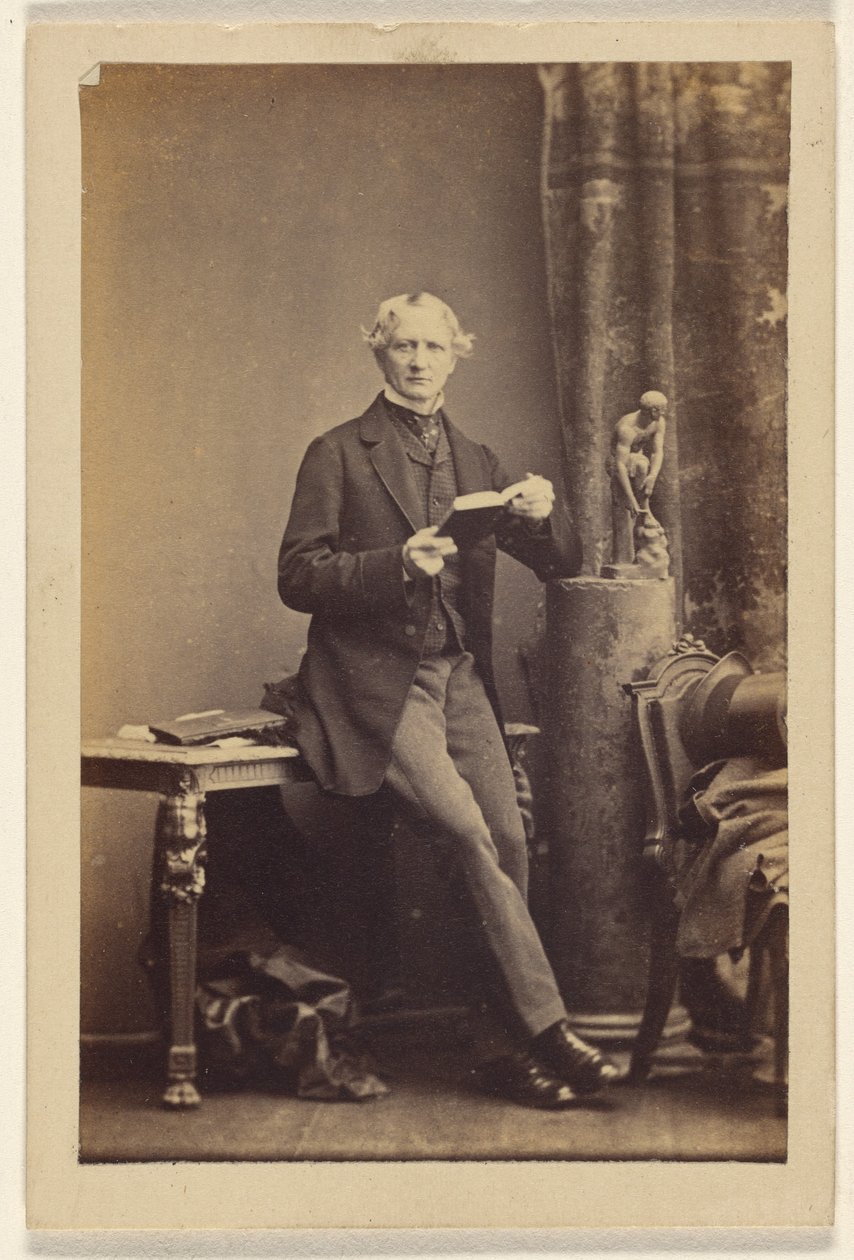 [Homem não identificado sentado numa mesa, segurando um livro aberto]. de Camille Silvy