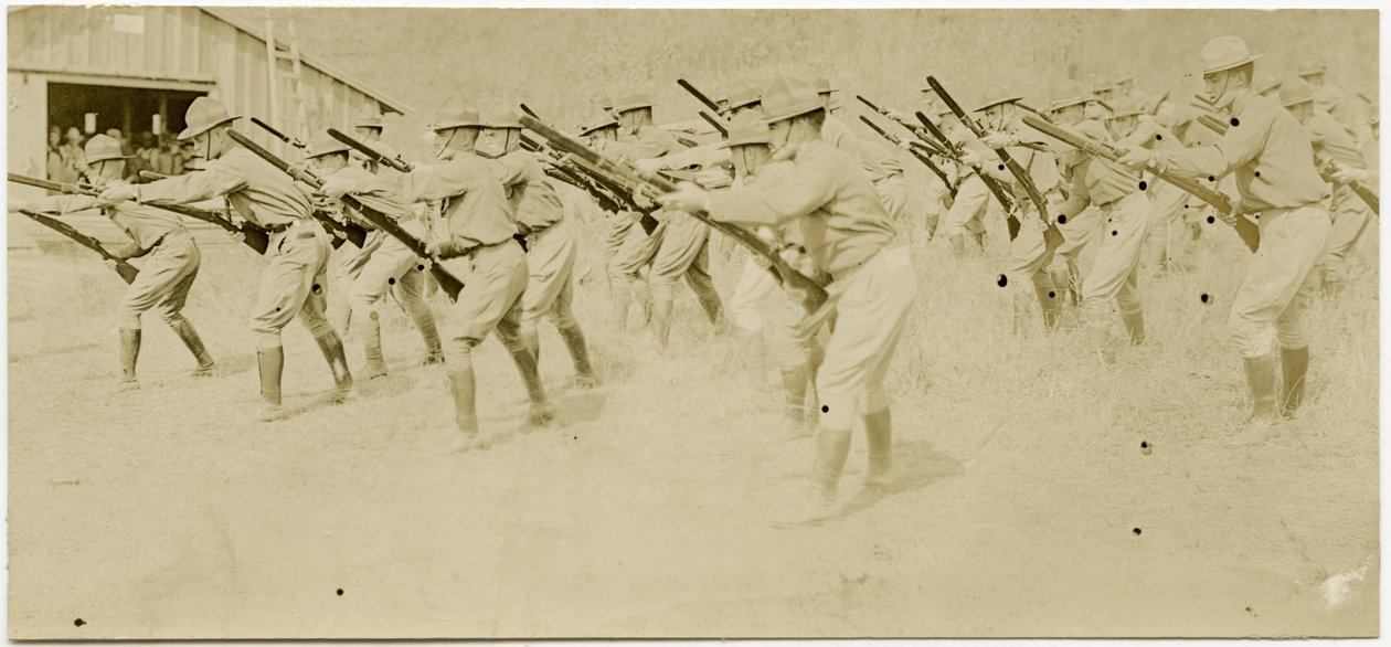 Soldados praticando rifle se move em uma área aberta, enquanto outros observam de Carl Michel