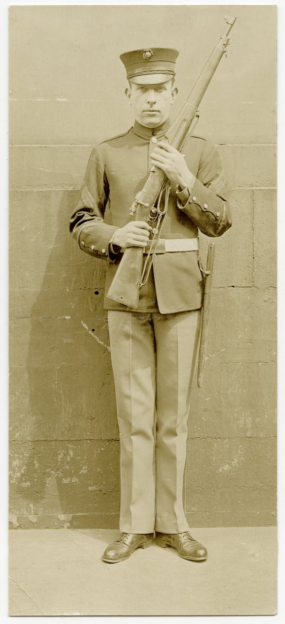 Soldado uniformizado posando para uma foto na frente de um muro de concreto de Carl Michel