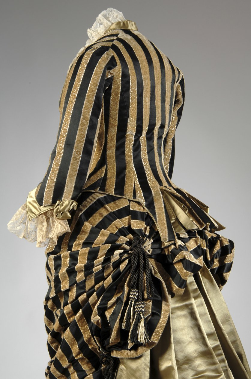 Vestido de noite, c.1884 (vista parcial oblíqua das costas). Cetina de seda e veludo cortado, renda, borlas de fio de seda e franja. Charles Frederick Worth, França. de Charles Frederick Worth