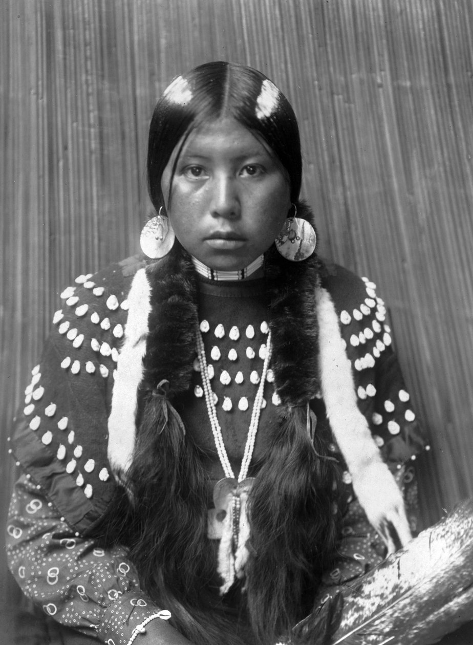 Mulher indiana Kalispel, riscas brancas pintadas no cabelo, brincos de disco de concha, vestido de manta decorado com dentes de alce, c. 1910, foto Edward S. Curtis de Edward Sheriff Curtis
