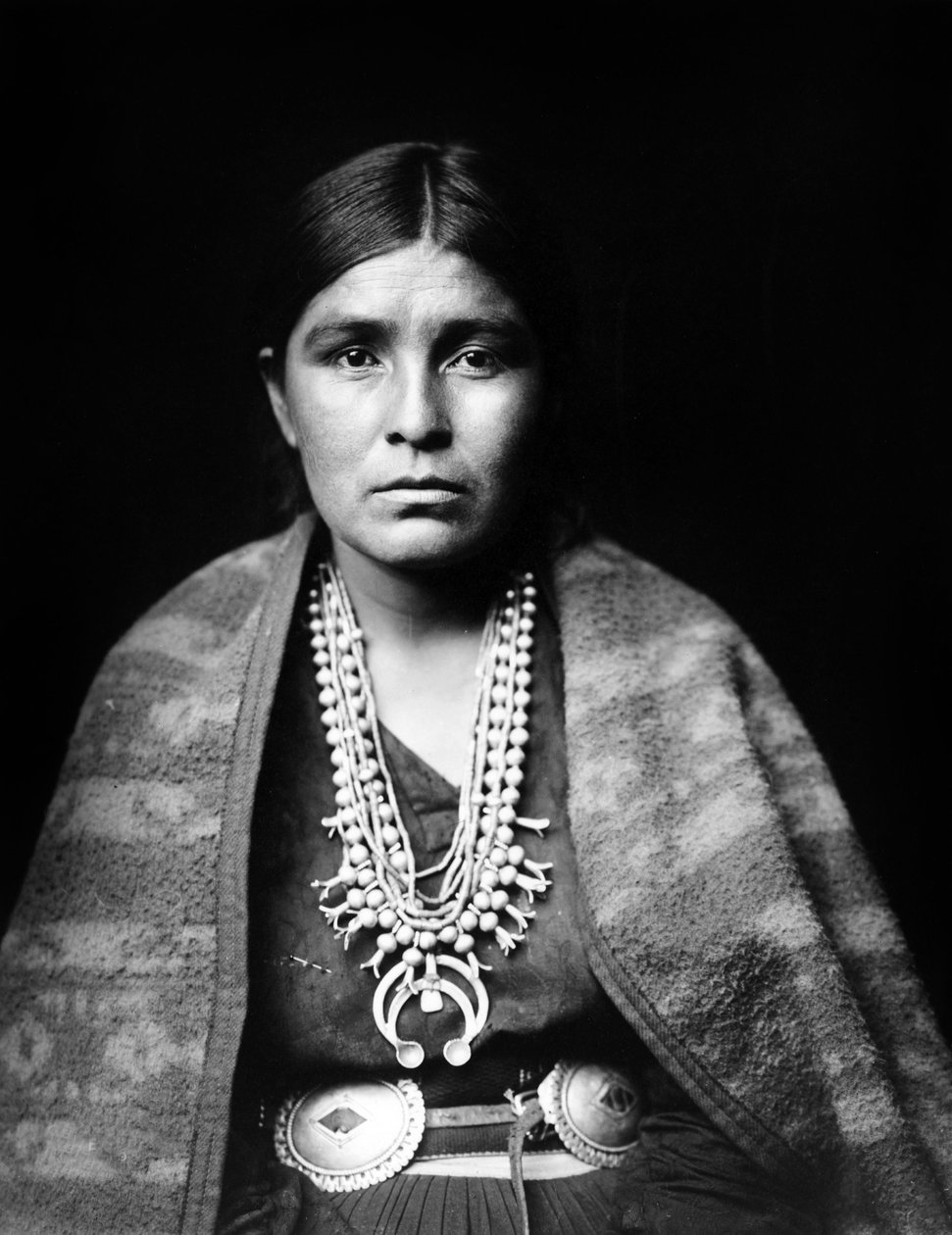 Mulher navajo usando colar de flor de abóbora prateada, cinto concho, manta drapeada sobre ombros, c. 1904, foto Edward S. Curtis de Edward Sheriff Curtis