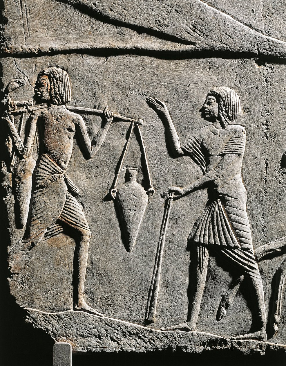 Vida num acampamento militar: carregador de água a receber ordens de um oficial, relevo do túmulo de Horemheb em Saqqara. Pormenores. de Egyptian 18th Dynasty