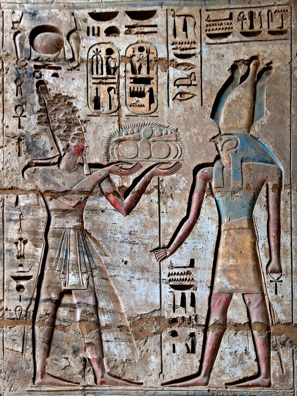 Antiquite egípcio: primeira corte, detalhe de relevos pintados retratando o faraó levando oferendas ao divinita Horus. Templo Funerário de Ramsés III (1187-1156 AC). Luxor, Medinet Habou, Egito. de Egyptian 20th Dynasty