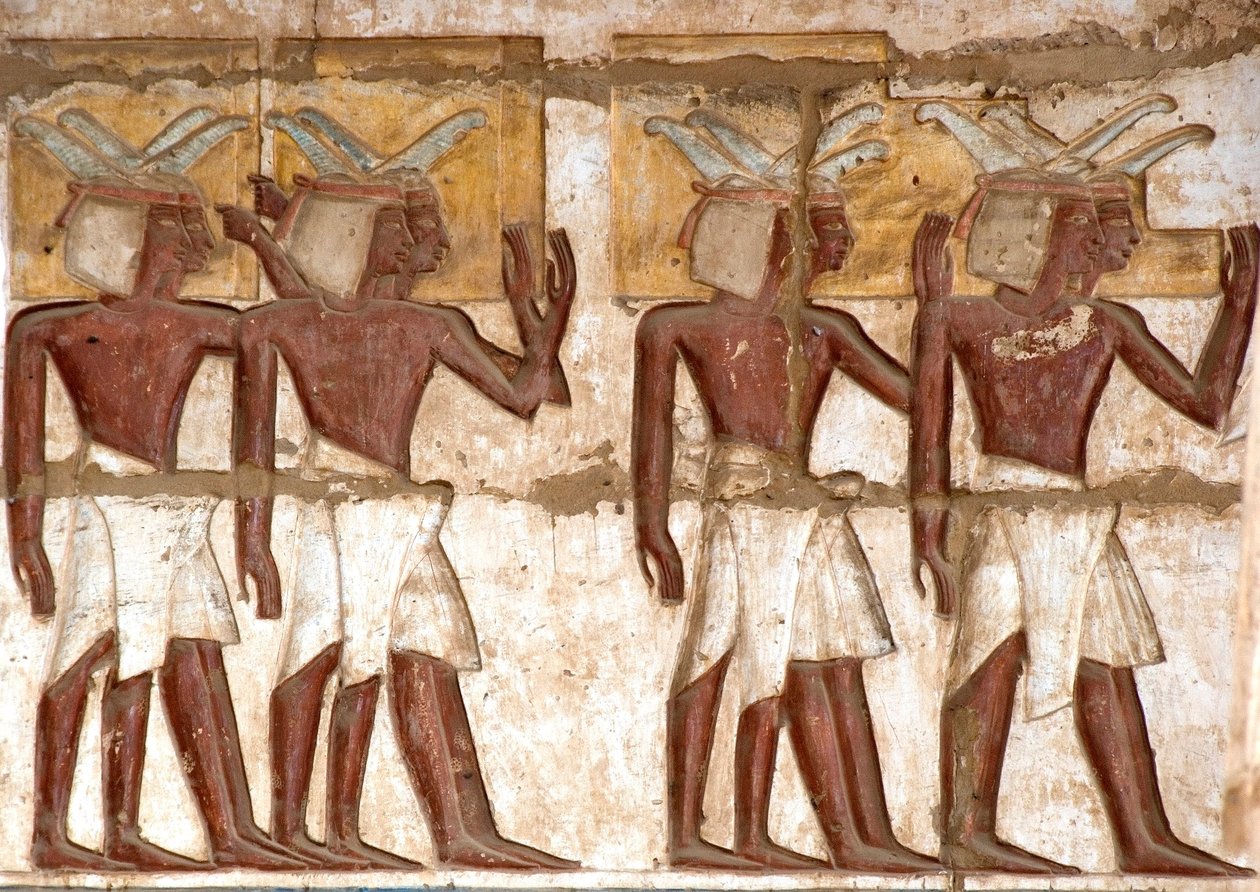 Antiquite egípcio: primeira corte, detalhe de relevos pintados representando um grupo de núbios trazendo oferendas ao faraó. Templo Funerário de Ramsés III (1187-1156 AC). Luxor, Medinet Habou, Egito de Egyptian 20th Dynasty