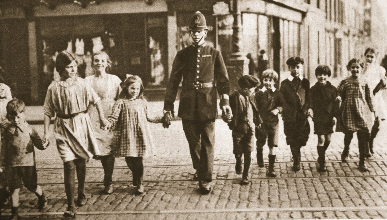 Um bobby na batida ajudando as crianças do outro lado da rua no final do dia letivo, de Wonderful London, publicado em 1926-27 (fotogravura) de English Photographer